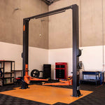 Tufflift EAE EE-C9LPA 2 post hoist in a workshop setting with the arms raised slightly off the ground