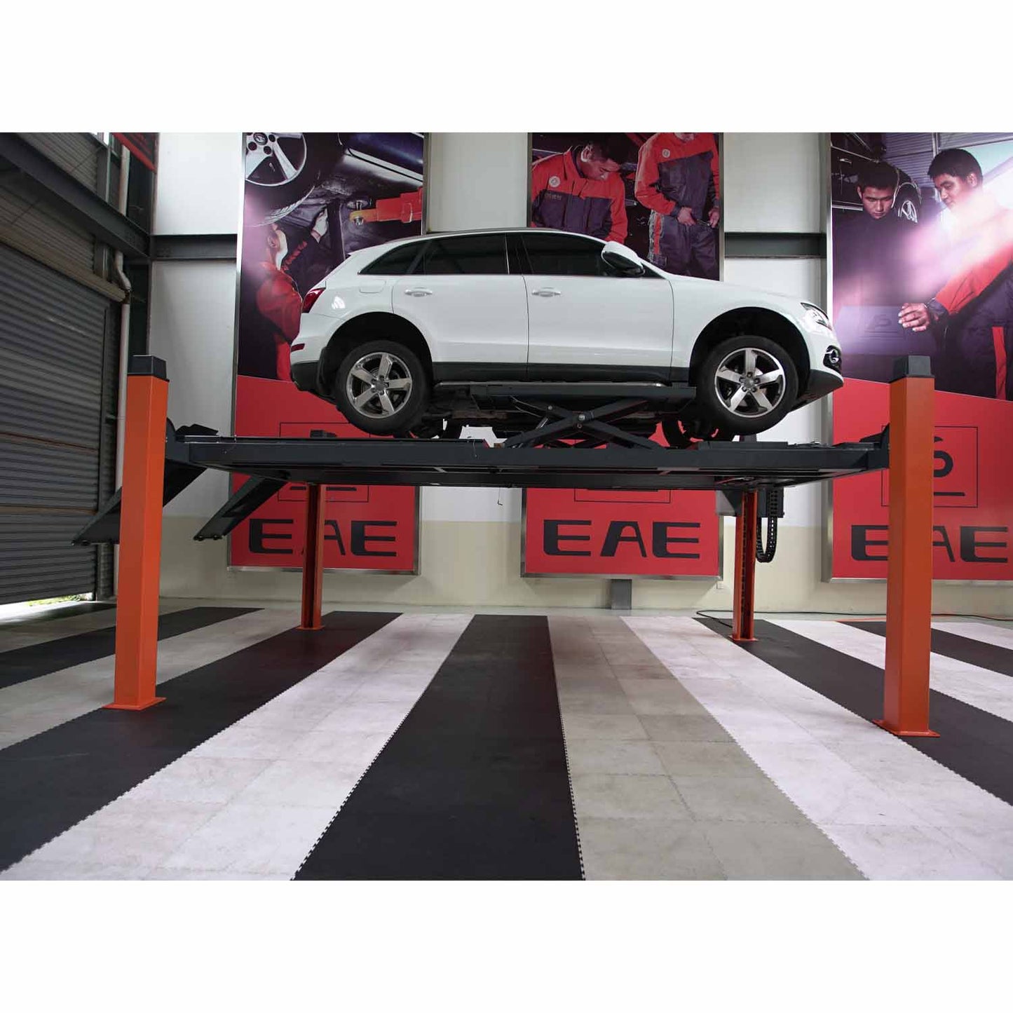 White SUV elevated on a four-post car hoist with orange columns, demonstrating vehicle alignment and servicing in an indoor automotive workshop, featuring EAE branding on the walls. - 4 Post Wheel Alignment Hoist - 4 Ton | EE-6435V2.B.48L.40T