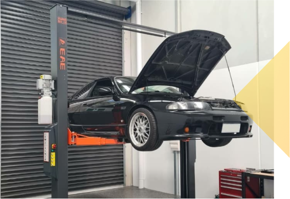 Car being lifted up in 2 post hoist