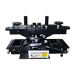 A black air pump rolling jack with a set of adapters and pads.