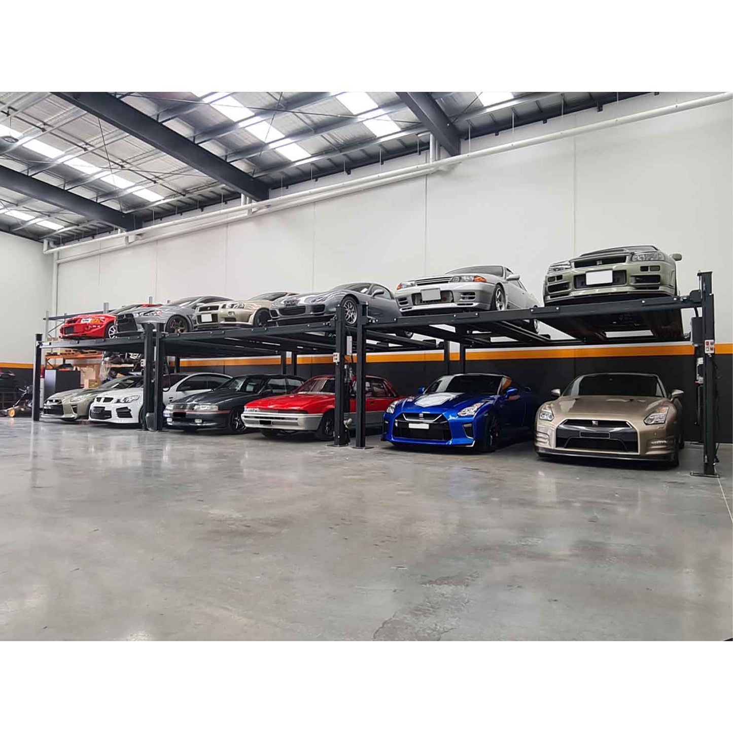 Indoor automotive storage facility with two levels of cars on four-post car lifts, showcasing various vehicles neatly parked in a spacious and well-organized environment. - 4 Post Twin Platform Parking Hoist – 4 Ton | TLD4.0TPL5.0M