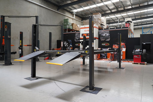 A mechanic installing a vehicle hoist