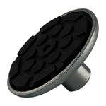 A close-up of a rubber pad with a textured black surface and a metal base, designed for stability and protection in vehicle lifting setups.