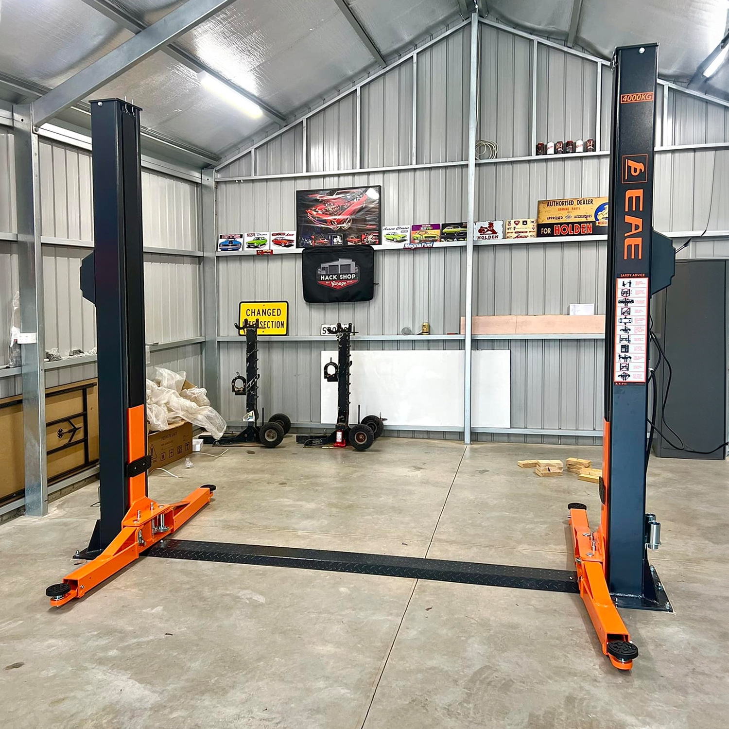 A Tufflift 2 post baseplate car hoist positioned centrally in a modern garage - 2 Post Baseplate Hoist - 4 Ton | EE-F9