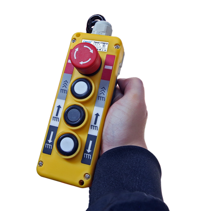 Handheld control panel with buttons and an emergency stop for operating a lift, showcasing user-friendly and safe controls for lifting equipment.