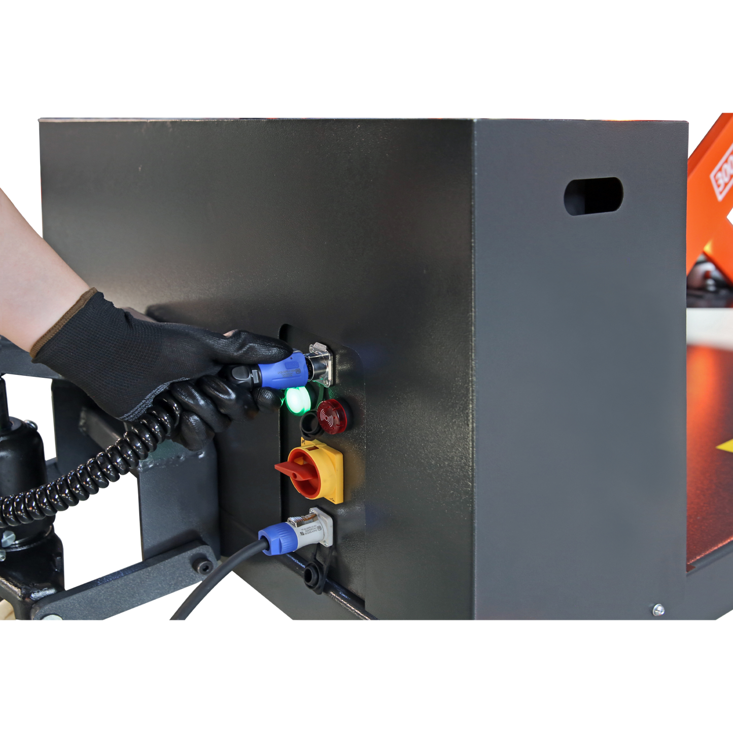 Gloved hand connecting a cable to a control panel on a lift, illustrating the setup and power connections for operating heavy-duty lifting equipment.