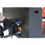 Gloved hand connecting a cable to a control panel on a lift, illustrating the setup and power connections for operating heavy-duty lifting equipment.