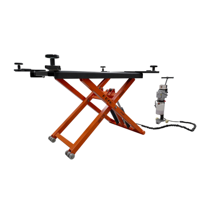 An orange EAE hydraulic scissor lift elevated at full height. The control unit and wiring are visible nearby, showcasing its compact design for vehicle maintenance.