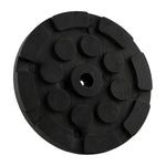 Black circular hoist pad with a central hole and raised sections, designed for use with car hoists to provide stability and grip.