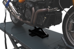 A motorcycle is positioned on a hoist, with an optional jack lifting the bike for maintenance. The hoist is equipped with tie-down straps and a sturdy platform, ensuring stable support during work.