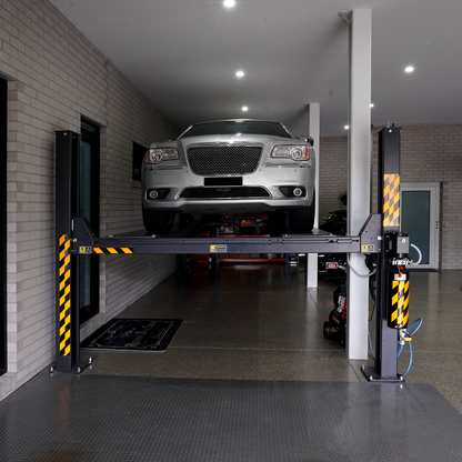 Front view of a limousine parked on a 7-meter 4 post hoist in a residential garage.