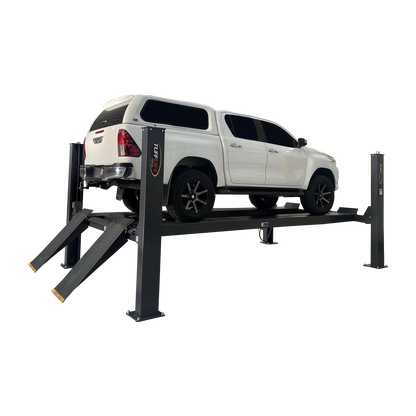 White SUV lifted on a four-post car hoist with drive-on ramps in an industrial garage, ready for maintenance and inspection. - 4 Post Workshop Hoist - 6 Ton | TL6.0PH