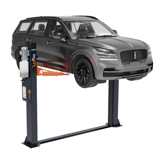 A grey SUV lifted on a two-post car hoist, with the lift arms positioned under the vehicle’s chassis for support.